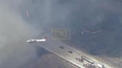 Main image for Firefighters are battling a large brush fire burning on a hillside near the 71 Freeway in Chino Hills.