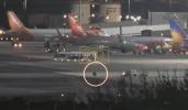 Main image for Airport Ground Crews Chase Down a Tire Rolling Free Across the Airport.