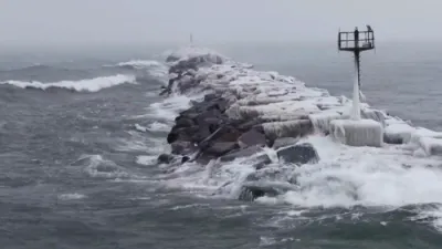 Drone Captures Waves Crashing Over Icy Lake Michigan Breakwall.