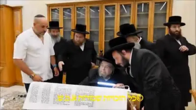 The Belzer Rebbe Shlit"a writes a letter in a Sefer Torah l'iluy nishmas a soldier who fell in the war
