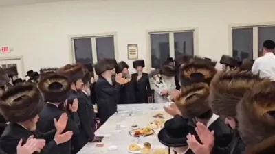 The Satmar Rebbe Shlit"a writing a letter and dancing with the Sefer Torah at the Hachnosas Sefer Torah last night, Motzei Shabbos, in Camp Satmar Maywood.