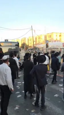 A Protester With Clothes Torn by Brutal Police in Holy Moments Davening Mincha at the Amud After Stormy Protests Against the Gezeiras HaGiyus.