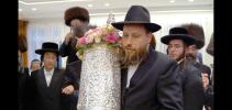 מתפּללי ביהמ"ד אַרגענטינא אין קרית יואל פרייען זיך ביים הכנס"ת פון א הערליכע ספרד'ישע ספר תורה