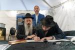 היסטאריע אין 'קאסטראמע': ספרי קודש אנטדעקט אין די ווענט פונעם בנין, און א כתיבת ספר תורה