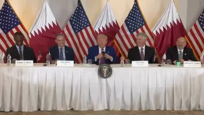טראמפ רעדט וועגן האנדל און עקאנאמיע זיצנדיג ביי א טיש מיט ביזנעס פירער.