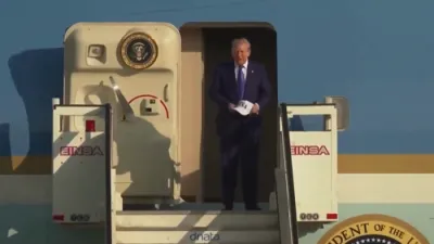 פרעזידענט טראמפ קומט אן אין האלאנד פאר די נאטא זיצונג טראגנדיג זיין "USA" היטל.