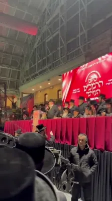 כ"ק אדמו"ר מצאנז קלויזענבורג שליט"א בעהט איבער די עולם ביים זיך צוריקקערן צו די מעמד סיום הרמב"ם אין קראונהייטס נאכן צוזאמפאלן אינמיטען א דרשה.