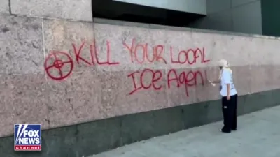 לאס אנדזשעלעס פראטעסטירער שפריצט אן א וואנט פון א פעדעראלע געביידע מיט א רוף צו הארגענען אייס אגענטן ביי א פראטעסט