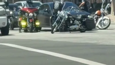 ווילדע כאאס אויף די גאסן: א מערצעדעס קראכט אריין אין א מאטארסיקל נאכדעם וואס בייקערס האבן ארומגערינגלט די קאר ביי א רויט לייט.