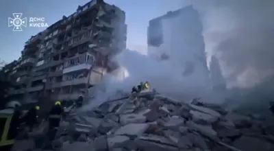 מען ראטעוועט מענטשן פון א צובראכענע געביידע אין קיעוו נאך א רוסישע אטאקע 