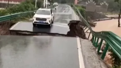 א ווייסע SUV קאר איז אריינגעפאלן אין א ברויזנדע טייך.. נאך וואס א בריק איז איינגעפאלן אין טשיינע 