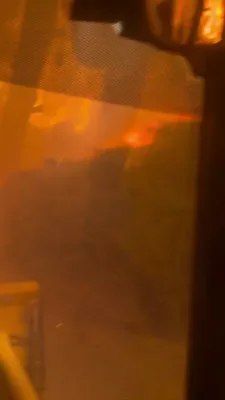 פלאמען רוקן זיך נענטער: שווערע מאשינערי קעמפט מיט א וואלדפייער נעבן רינאו.