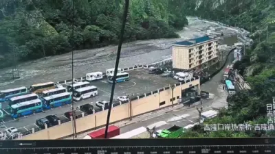 שוידערליכע סצענעס ווי א מאסיווע בלאטע-גליטש רייסט דורך א פארט ביים כינע-נעפאל גרעניץ און שליידערט ארום קארס.
