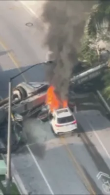 פייער באלי אויפן גאס: א דראון ווידיאו צייגט ווי א קרעין קראכט אריין אין א ווייסע SUV און פאראורזאכט א מאסיווע פייער אין די פינאנציעלע דיסטריקט