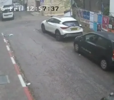 ווידעא: א דורכגייער ראטעוועט זיך סעקונדעס בעפאר א סוכה ווערט אראפגעבלאזן פון א באלקאן און קראכט אויפן גאס אין ירושלים