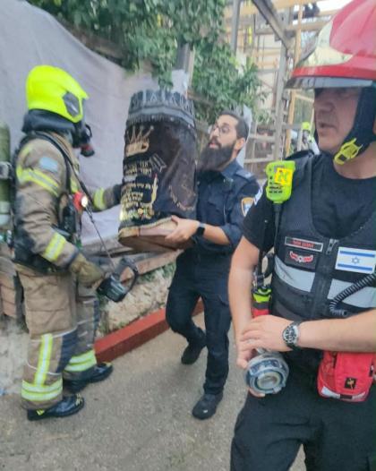א ספר תורה ווערט עוואקואירט פון די פלאמען אין מאה 